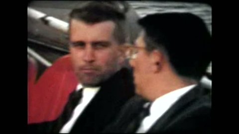 Cincinnati, 1950's. Quick pan of a number of white businessmen in the 50's talking and smoking on a boat. Close head shots.
