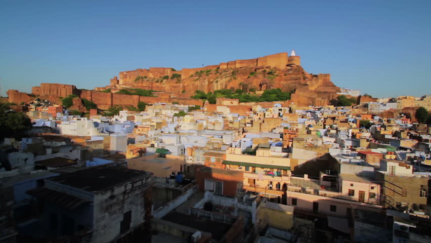 Cityscape view of the Mehrangarh Fort and the rooftops of the old blue city of Jodhpur, Rajasthan, India. Locked down shot against a blue sky.