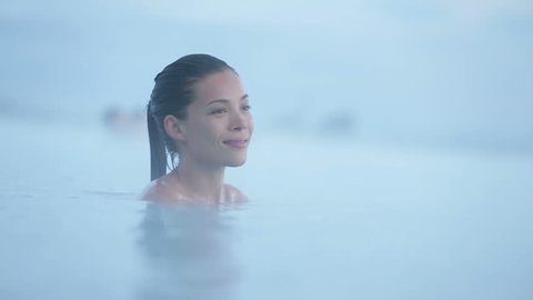 Geothermal spa. Woman relaxing in hot spring pool on Iceland. Girl enjoying bathing in a blue water lagoon Icelandic tourist attraction.