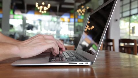 Man hands working on laptop computer in cafe