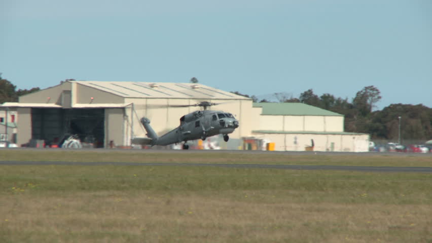 A sea hawk helicopter practices landing manoeuvres.  Heat haze visible in shot