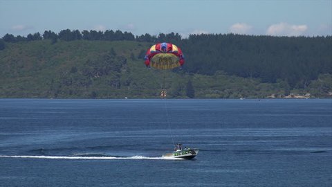TAUPO, NORTH ISLAND/NEW ZEALAND - JANUARY 25, 2015: Unidentified people parasailing from boat, Lake Taupo. The lake is the largest freshwater lake in New Zealand.