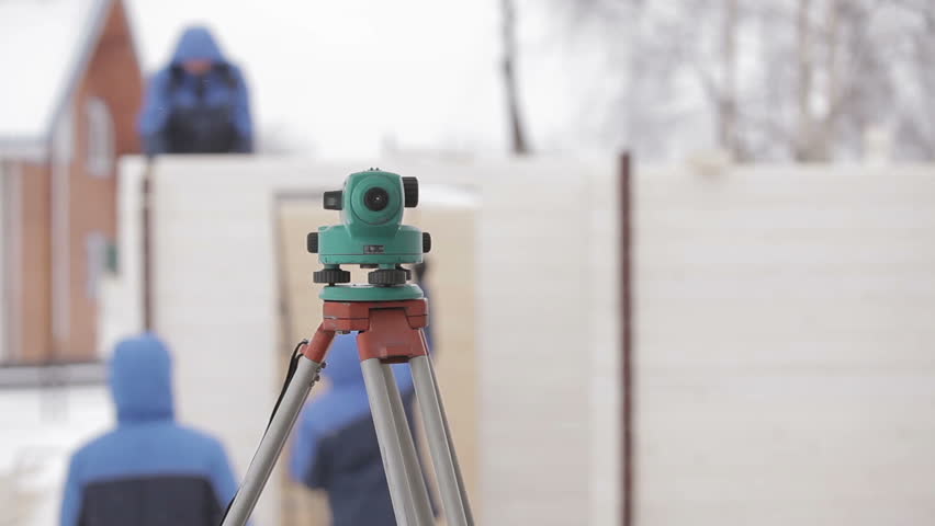 Worked as a builder in blue suits at a construction site in blue suits on the background Land surveyor total station. Royalty-Free Stock Footage #9267977