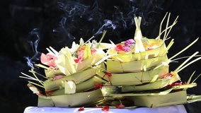Traditional balinese offerings to gods in Bali with flowers, money and aromatic sticks, Ubud, Indonesia