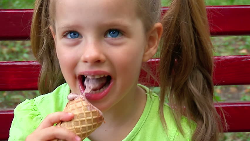 Similar to A little girl with golden long wavy hair eats an ice cream cone ...