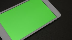 Green screen chroma display on silver PC tablet slow panning 4K 3840X2160 UHD video - Tablet PC with greenscreen display on wooden surface 4K 2160p UltraHD video