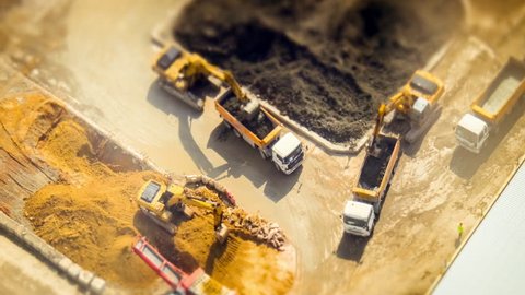 HONG KONG - JAN 23, 2015: Excavators and tipper tracks working at construction. Hong Kong. Time lapse form aerial view point, tilt shift