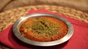 Delicious traditional Turkish kunefe and cream kaymak with pistachio on it. Served hot and with syrup hd video