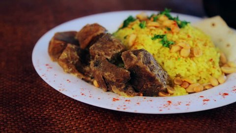 Food, boiled rice with meat and peanuts. Arabic pilaf with meat sauce and peanuts. National Asian and Arabic cuisine. Dish of rice and meat. Pilau, rice, risotto.