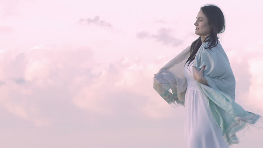 cute woman feeling cold with beautiful clouds in the background
