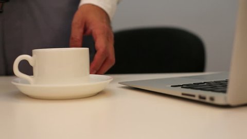 pouring coffee to coffee cup on office desk