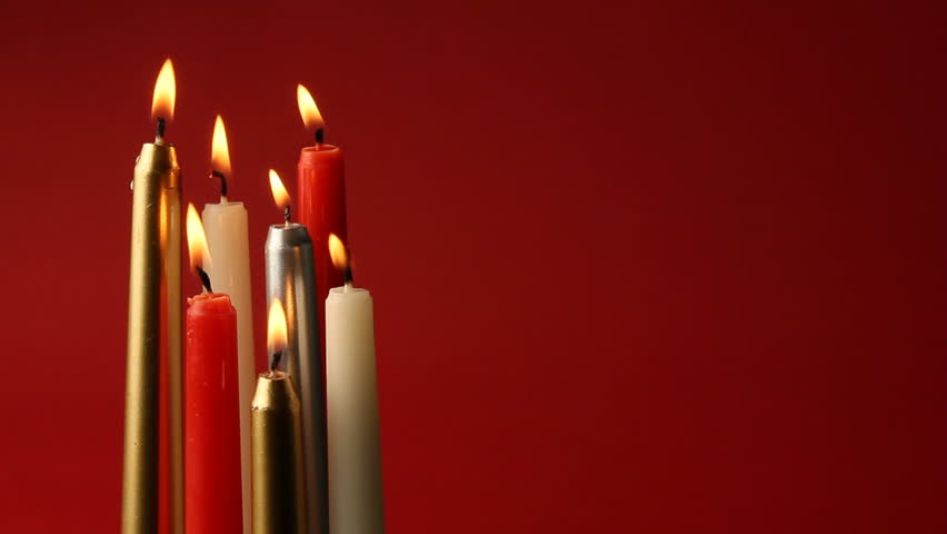 Many colorful candles on a red background
