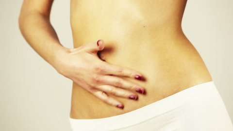 Closeup of healthy fit woman flat stomach. Woman stroking her belly