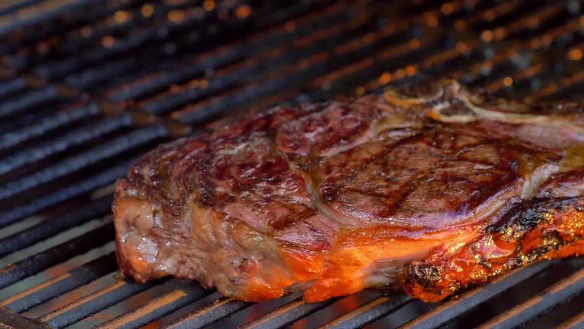 ribeye steak on charcoal grill