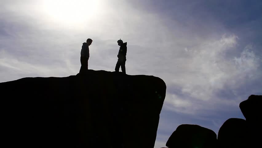 2 Male Figures Fighting on Clifftop - Silhouettes Against Sky