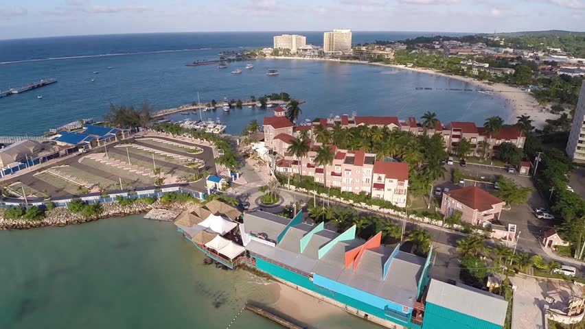 Aerial view of the bay in Jamaica in Ocho Rios. Hotels and resorts in the distance line the shoreline.