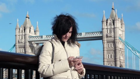 London bridge: tourist woman using smartphone in London