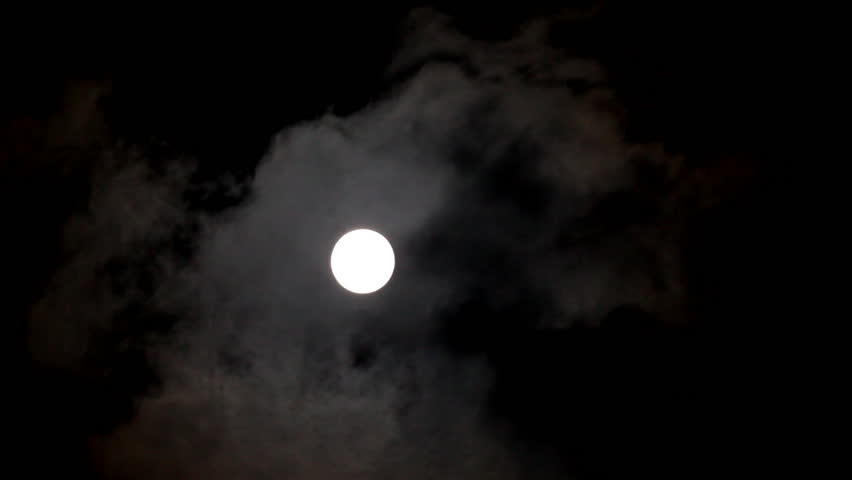 timelapse of moon moving between clouds
