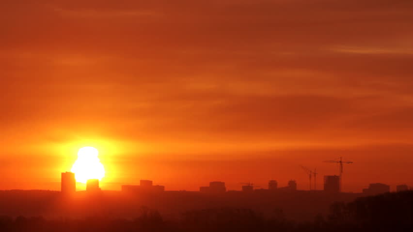 sunrise over distant town with fog