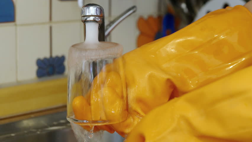 woman washing dishes at home after lunch or dinner