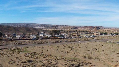 BARSTOW, CA/USA - March 5, 2015: Long shot from a distance of small town suburban homes in the desert. A small community neighborhood is nestled between hills and highway.