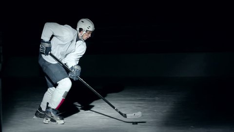 Side view of forward hockey player successfully attacking gates in slow motion