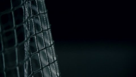 Macro shot of puck flying into gates in slow motion