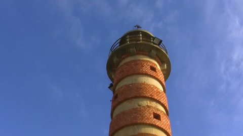Round brick tower on blue sky background(camera pass by)