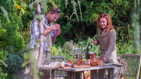 Couple smelling the tea. Slow motion RAW footage of a couple smelling the home made tea at the garden table in the beautiful scenery on the sunny day.