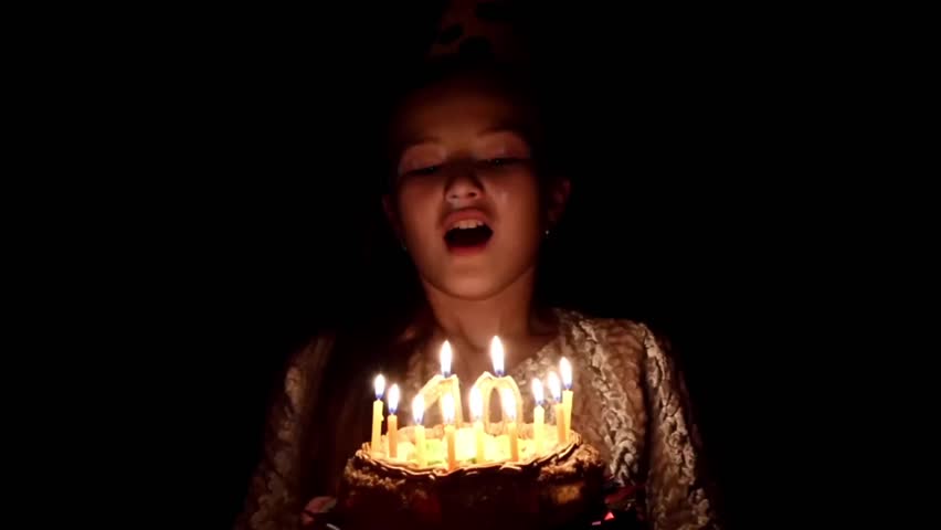 The birthday girl blows out the candles on a birthday cake, she was 10 years old,The birthday girl blows out the candles, slow motionon 