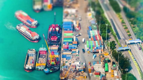 HONG KONG - JAN 23, 2015: Cargo ships loaded by crane with cargo containers at a busy port terminal. Hong Kong. Time lapse form aerial view point