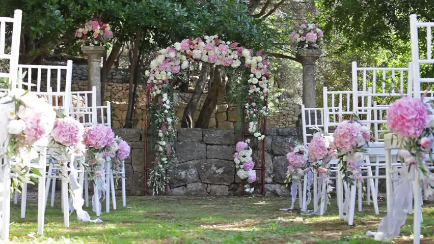 outdoor place for a wedding arch decorated with fresh flowers and Chiavari chairs