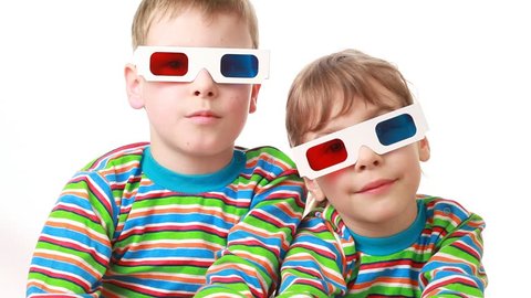 Little boy and little girl in striped shirts with long sleeves sit in anaglyph (3d) glasses applaud