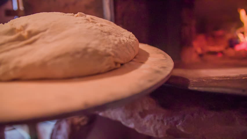 Bough going in to the bread oven. Close up slow motion footage of a bough on the wooden board going in to the bread oven to bake in the country house. | Shutterstock HD Video #9394328