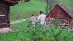 Couple walking of in the country side. Slow motion RAW footage of a couple walking of the wooden house in the middle f a country side on the beautiful sunny day.