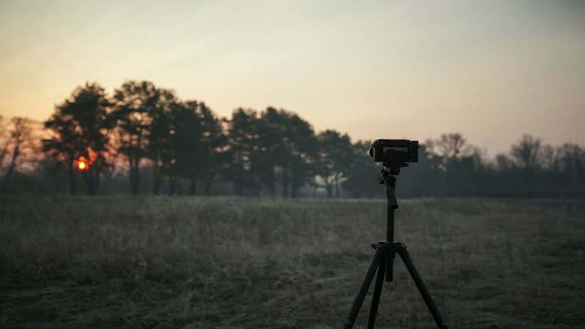 Professional camera on tripod  takes  picture of nature sunset. 4K (4096x2304)   

