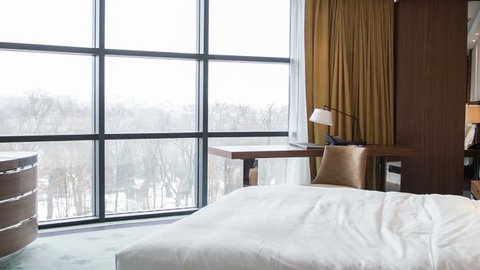 Elegant room with spectacular winter view. Shot entering a luxurious hotel bedroom.