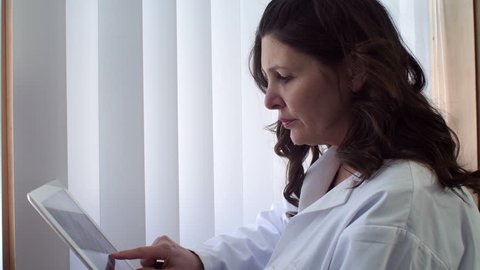 Hispanic female doctor looking at tablet