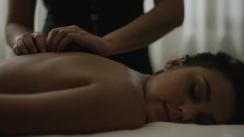 Slow motion panning shot of woman having hot stone massage in spa: Arenal, La Fortuna, Costa Rica