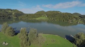 Landscape with a lake on the countryside. Helicopter camera RAW footage of a lake in the middle of a countryside in beautiful scenery on a sunny day.
