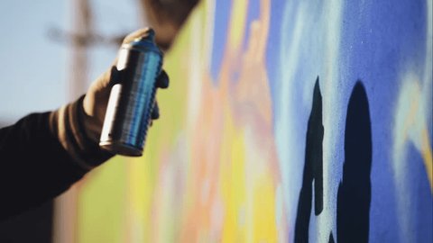 Стоковое видео: Graffiti Artist Paint Spraying the Wall, Urban Outdoors Street Art Concept, Handheld 1920x1080 cinematic toned HD footage.