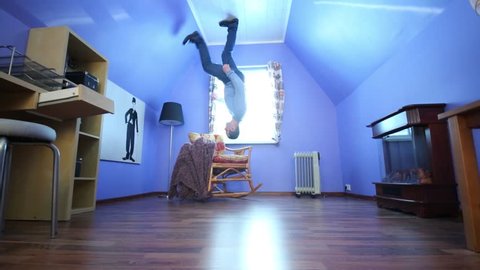 Man on ceiling upside down in blue room in inverted house
