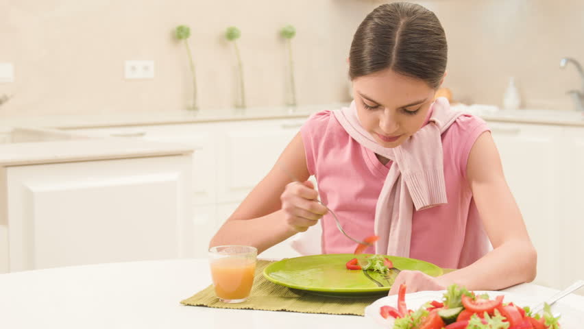 little daughter has finished her lunch and waits for dessert from mom