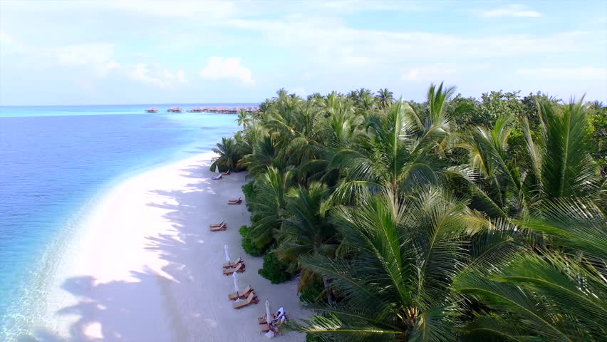 AERIAL: Luxury island resort on exotic white sand beach Royalty-Free Stock Footage #9426038