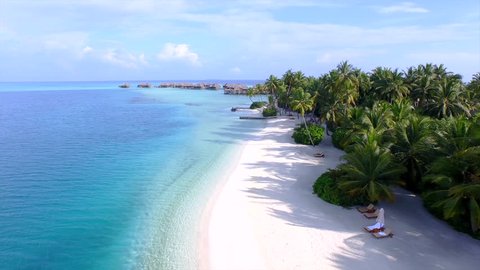 AERIAL: Luxury island resort on exotic white sand beach