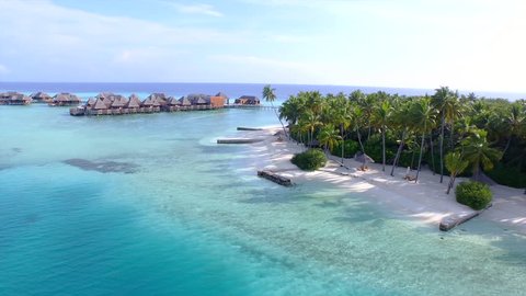 AERIAL: Luxury over-water bungalows in tropical lagoon