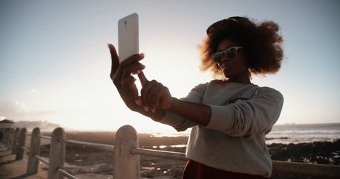 Happy African American hipster teen girl at the beach taking a selfie on her phone Stock Video