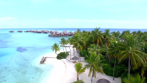AERIAL: Crystal clear water, exotic sandy beaches and ocean bungalows