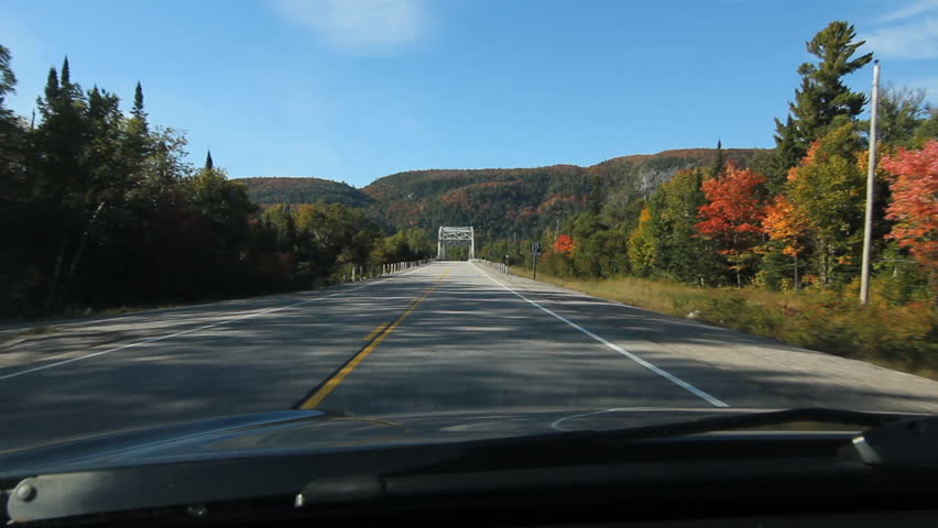 POV driving across a truss bridge. Driving across a truss bridge that crosses the Agawa River. White van passes. Trans Canada HWY No 1 or Hwy ON-17 in Northern Ontario, Canada.