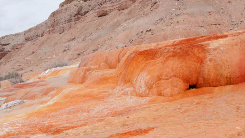 A man made geyser near Green River Utah called Crystal Geyser.  Formed by drilling for oil and hitting a water aquifer.  Water leaves mineral deposits leaving an orange travertine.
